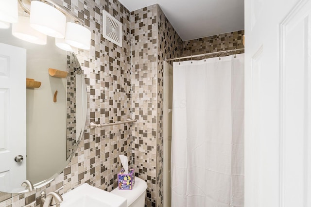 full bath with curtained shower, visible vents, and tile walls