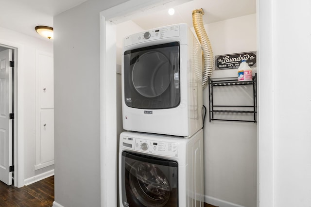 clothes washing area with laundry area, dark wood-type flooring, and stacked washer / drying machine