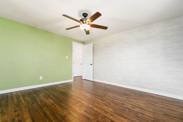 empty room featuring ceiling fan, dark wood-style flooring, and baseboards