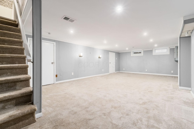 below grade area with visible vents, baseboards, light colored carpet, stairs, and recessed lighting