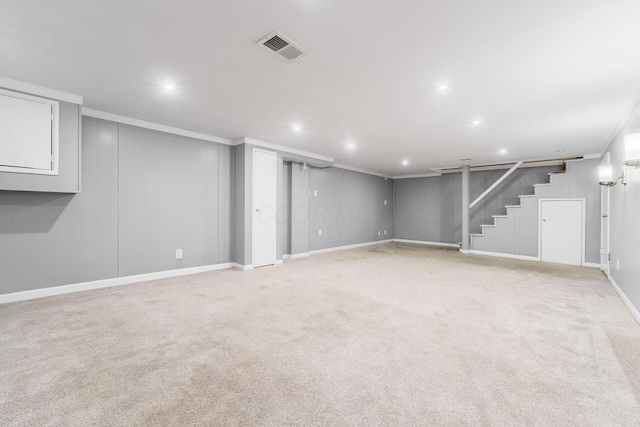 finished below grade area with recessed lighting, light colored carpet, visible vents, ornamental molding, and stairs