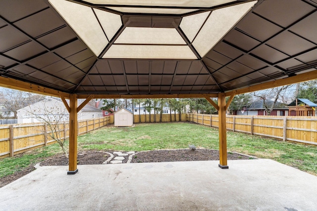 view of patio featuring a fenced backyard, an outdoor structure, a gazebo, and a shed