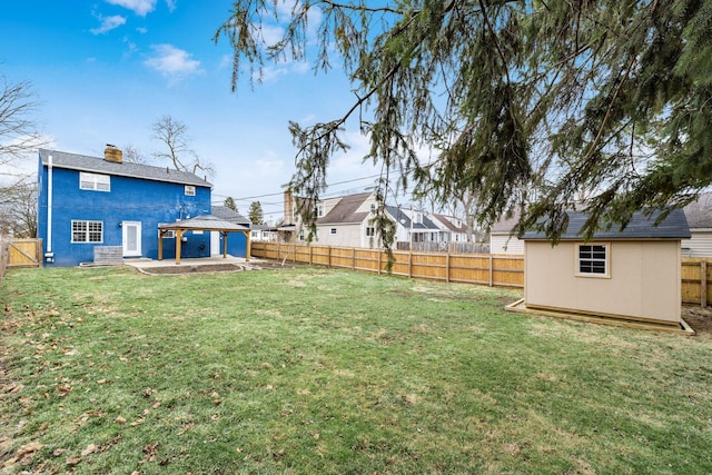 view of yard featuring a storage shed, a fenced backyard, an outdoor structure, and a gazebo