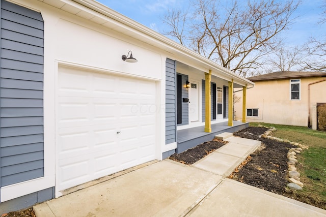 property entrance featuring a garage, covered porch, and concrete driveway