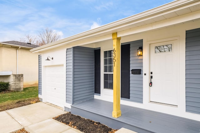 entrance to property featuring a porch and an attached garage