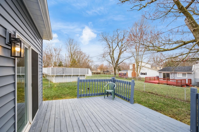 wooden deck featuring a yard and fence