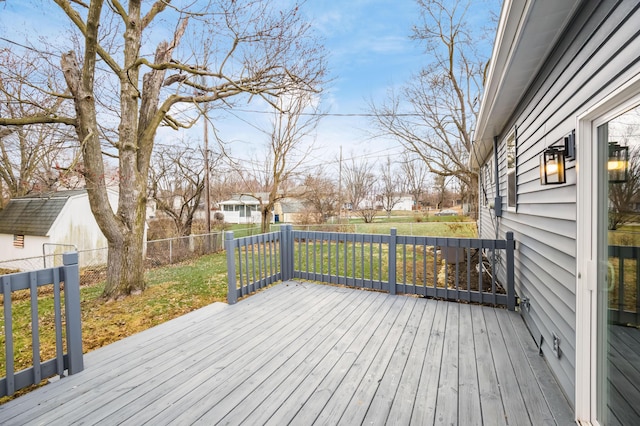 deck with a fenced backyard, a lawn, and an outdoor structure