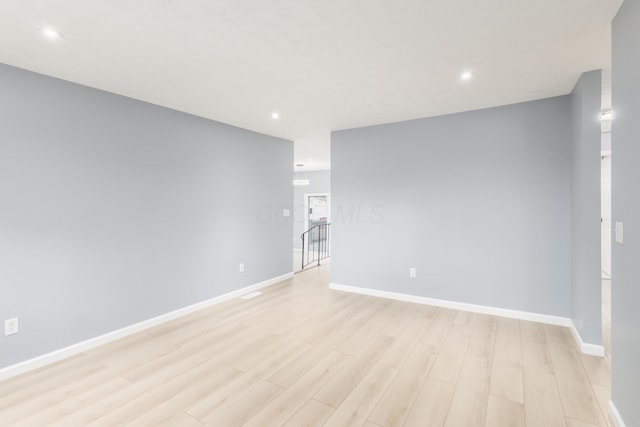 unfurnished room with recessed lighting, light wood-type flooring, and baseboards