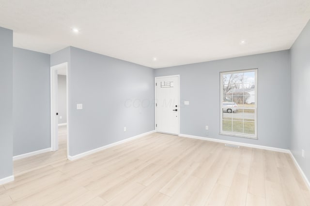 unfurnished room with recessed lighting, visible vents, light wood-style flooring, and baseboards