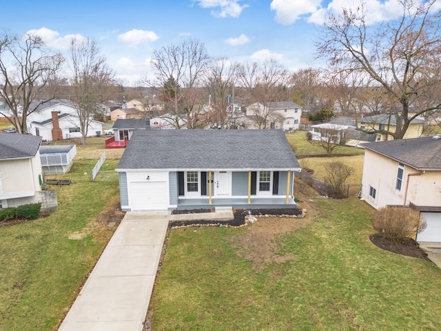 view of front of house featuring driveway, a shingled roof, a residential view, and a front yard