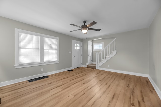 foyer entrance with a ceiling fan, visible vents, baseboards, stairway, and light wood-type flooring