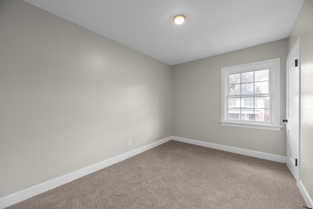 carpeted spare room with baseboards