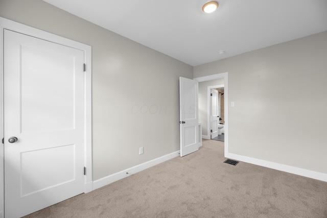 unfurnished bedroom with carpet flooring, visible vents, and baseboards