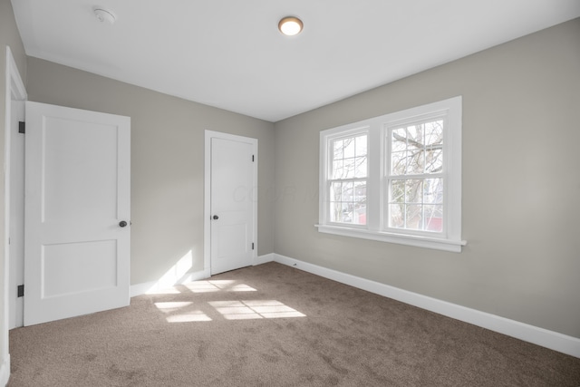 unfurnished bedroom with carpet floors and baseboards