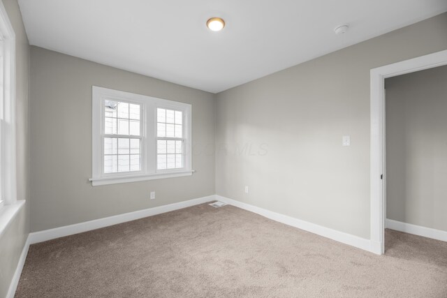 carpeted spare room featuring baseboards