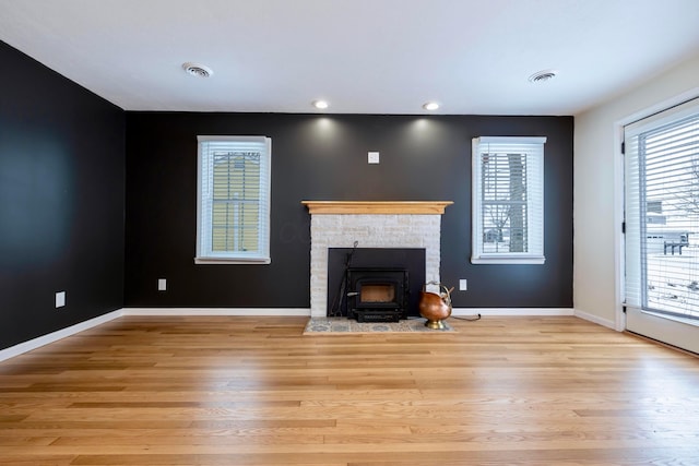 unfurnished living room featuring wood finished floors, visible vents, and baseboards