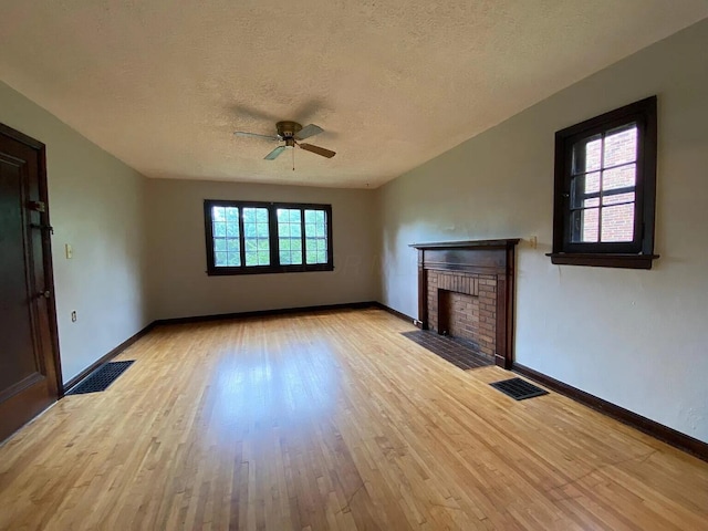 unfurnished living room featuring visible vents, a fireplace, and light wood-type flooring