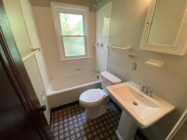 bathroom with toilet, shower / bath combination, and a sink