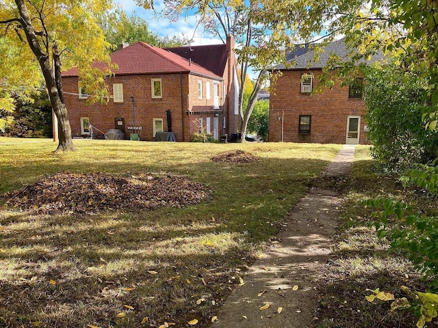 exterior space with brick siding, central AC unit, and a lawn