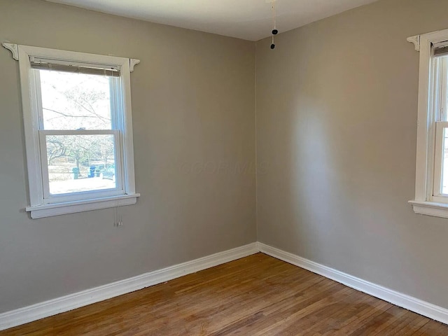 empty room featuring wood finished floors and baseboards