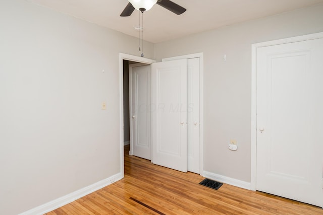 unfurnished bedroom with visible vents, baseboards, light wood-style floors, and a ceiling fan