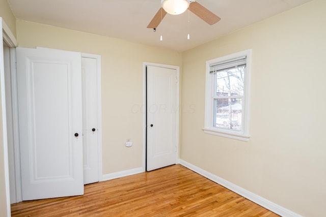 unfurnished bedroom featuring light wood-style flooring, baseboards, and ceiling fan