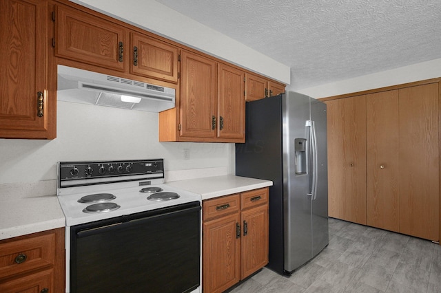 kitchen with range with electric cooktop, stainless steel fridge with ice dispenser, under cabinet range hood, light countertops, and brown cabinetry