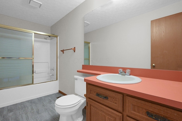 full bathroom with visible vents, toilet, a textured ceiling, shower / bath combination with glass door, and vanity