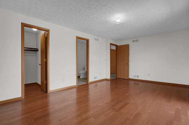 interior space with visible vents, wood finished floors, and a spacious closet