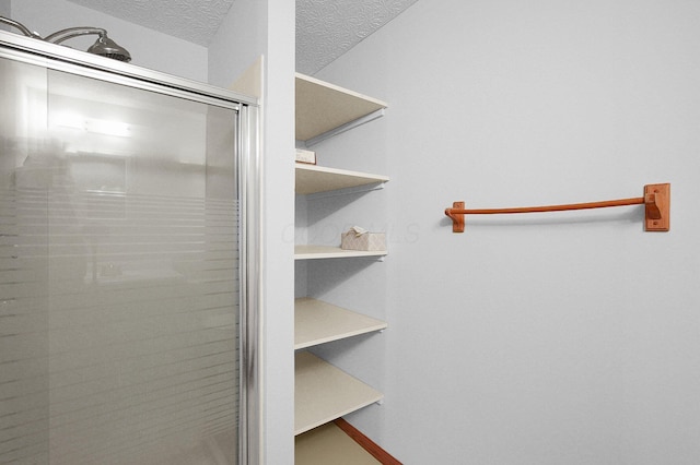 full bathroom with a stall shower and a textured ceiling