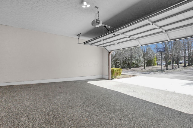 garage featuring a garage door opener and baseboards