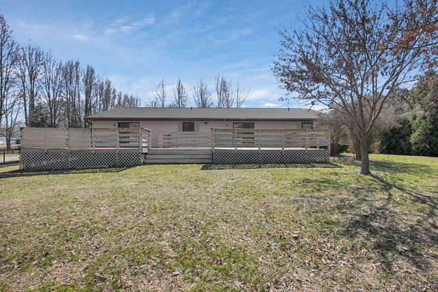 rear view of property featuring a lawn and a wooden deck