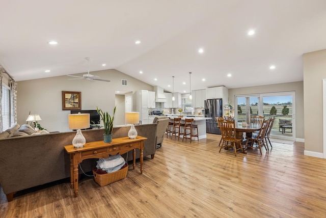 living room featuring recessed lighting, visible vents, vaulted ceiling, and light wood-style flooring