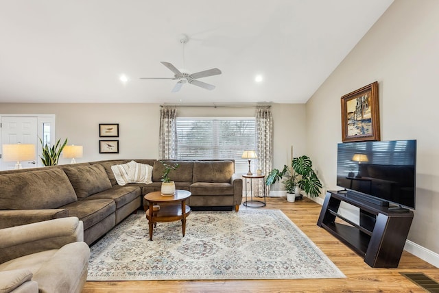 living area with lofted ceiling, visible vents, ceiling fan, light wood-type flooring, and baseboards