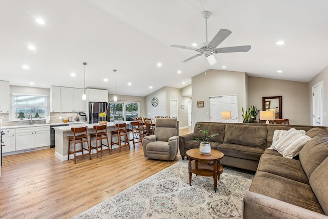 living area featuring ceiling fan, light wood-style flooring, vaulted ceiling, and recessed lighting