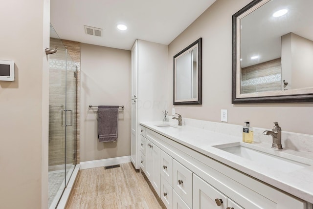 bathroom featuring a stall shower, a sink, and visible vents