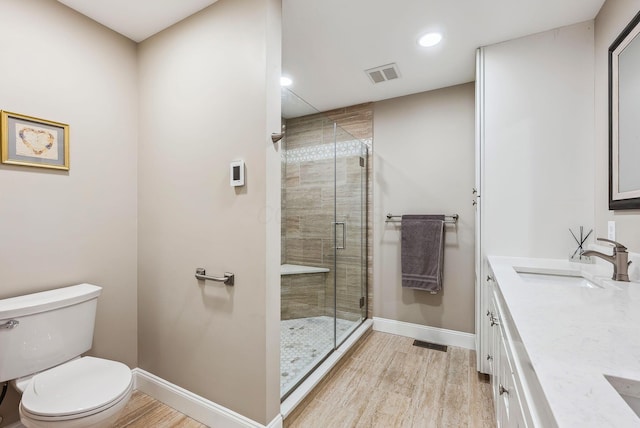 bathroom with toilet, visible vents, a sink, and wood finished floors