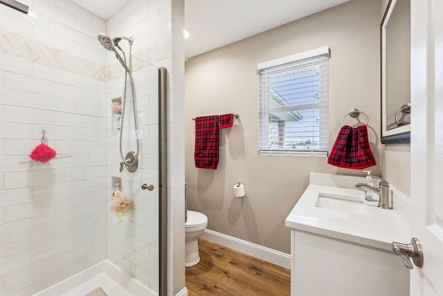 full bath with a stall shower, wood finished floors, and vanity