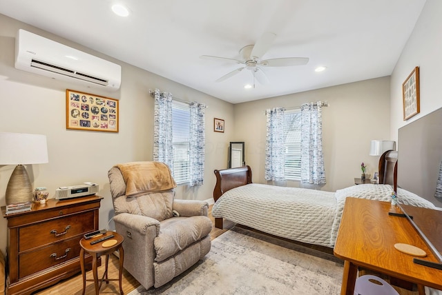 bedroom featuring light wood finished floors, multiple windows, a wall mounted air conditioner, and recessed lighting