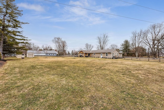 view of yard with an outbuilding and fence