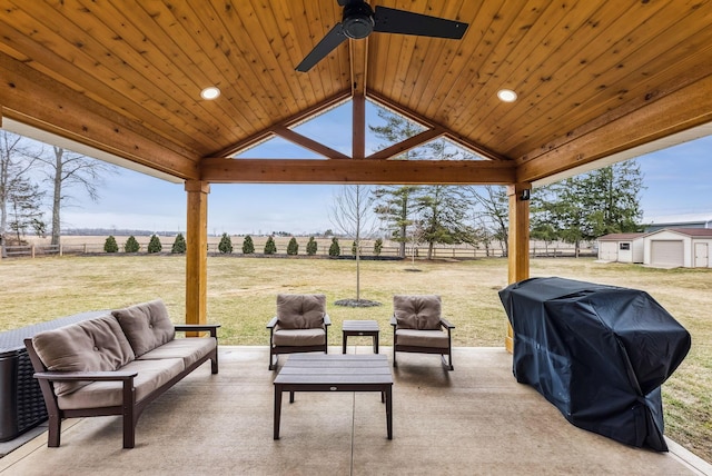 view of patio / terrace with grilling area, an outdoor hangout area, a ceiling fan, fence, and a rural view