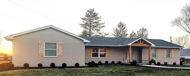 ranch-style home with brick siding and a front yard