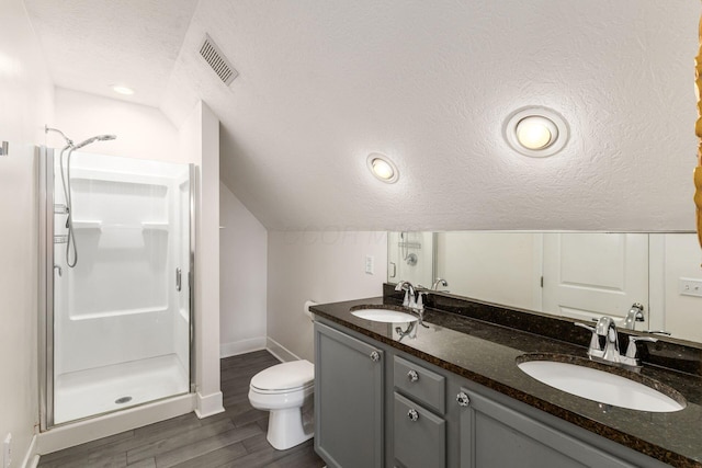 bathroom with a textured ceiling, a sink, visible vents, and a shower stall