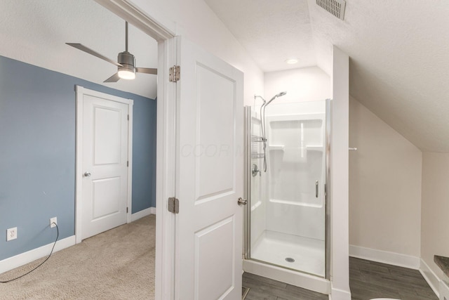 full bath with lofted ceiling, a shower stall, visible vents, and baseboards