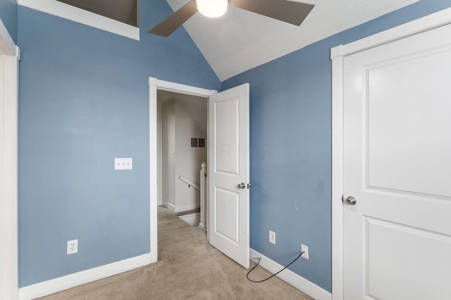 unfurnished bedroom featuring carpet floors, visible vents, baseboards, and vaulted ceiling