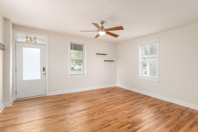 foyer entrance with light wood-type flooring, a healthy amount of sunlight, and baseboards