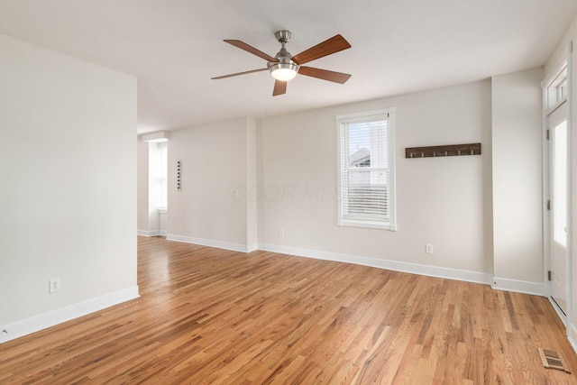 unfurnished room featuring ceiling fan, light wood finished floors, visible vents, and baseboards