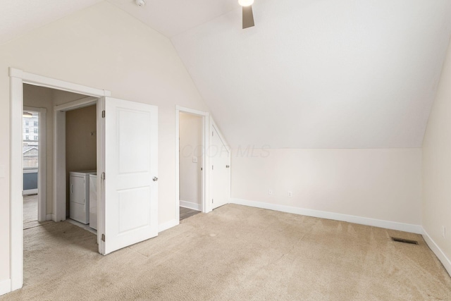 bonus room with light carpet, visible vents, vaulted ceiling, and washer and dryer