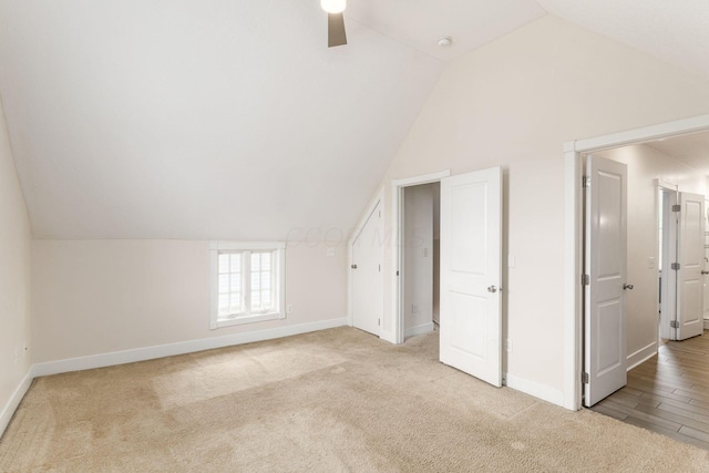 bonus room featuring lofted ceiling, carpet flooring, and baseboards