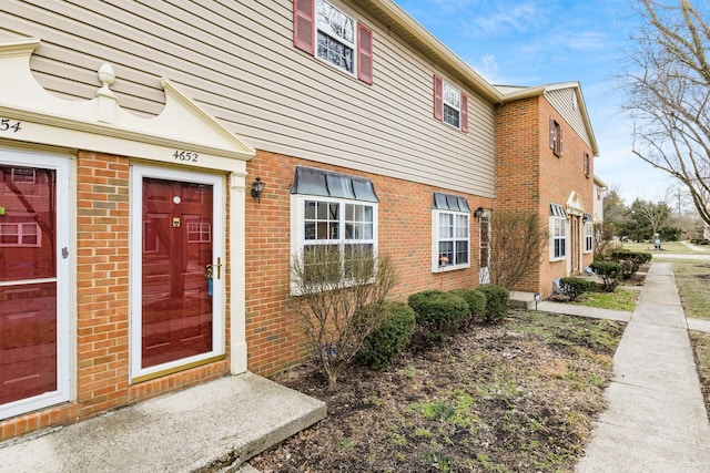 view of exterior entry with brick siding